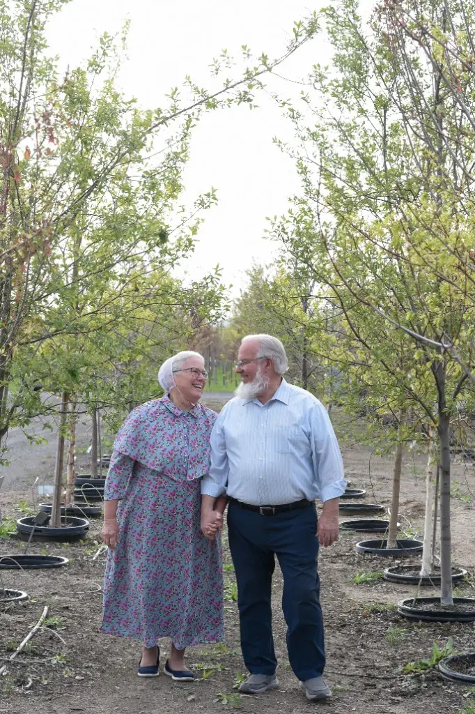 Everett and Sandra sharing a laugh among spring-green trees